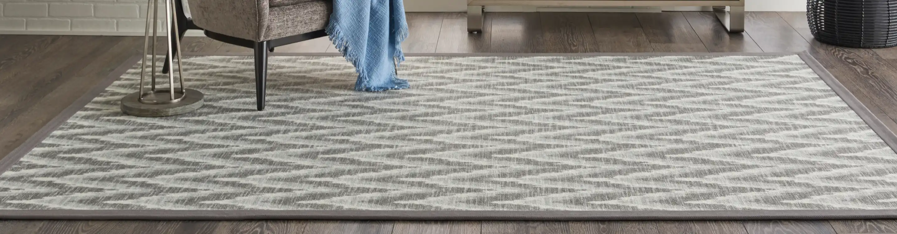 Grey patterned area rug on hardwood floor 